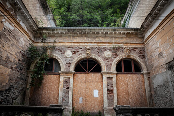 Decaying facade of Neptune baths, or Baile Neptune, an Abandoned building, formal thermal bath facilty, in ruin, waiting for renovation in Baile Herculane, in Romania, a spa thermal destination. . © Jerome