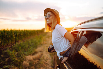 Towards adventure! Young woman is resting and enjoying the trip in the car. Lifestyle, travel,...