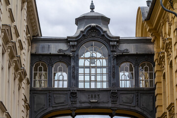 Focus on a skyway bridge, a bridge connecting two buildings, with a typical austro hungarian architecture, in the city center of Timisoara, Romania.
