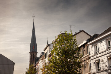 Fototapeta premium suburban dutch countryside village of the netherlands, called Vaals, in Limburg, with houses and residential buildings in the center with the catholic church of Sint pauluskerk and its clocktower