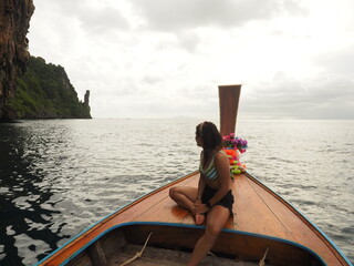 young woman in a long tail boat in thailand