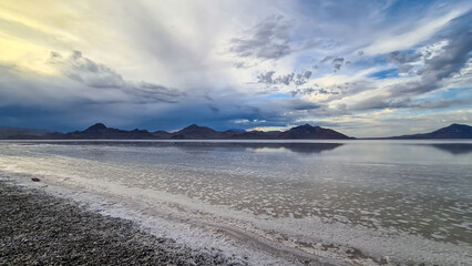 Scenic view of beautiful mountains reflecting in lake of Bonneville Salt Flats at sunset, Wendover, Western Utah, USA, America. Looking at summits of Silver Island Mountain range. Romantic atmosphere
