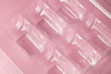 Transparent plastic bottle mould with pink background. Emptiness Concept.