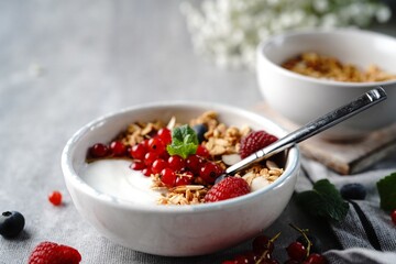 Granola yogurt bowl with rasberries red currants and blueberries | Healthy breakfast concept, selective focus