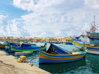 Fototapeta na wymiar Colorful boats moored in the fishing harbor of Malta Marsaxlokk
