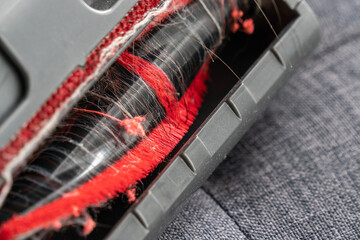 Close-up view of the hair and string stuck on the dust mite vacuum brush head.