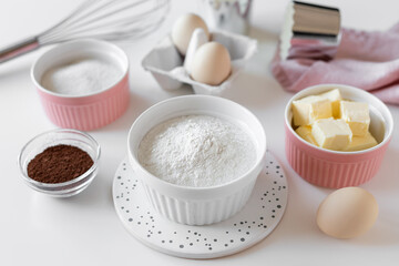 food ingredients for baking and kitchen utensils on the kitchen table. flour, butter, sugar, cocoa...