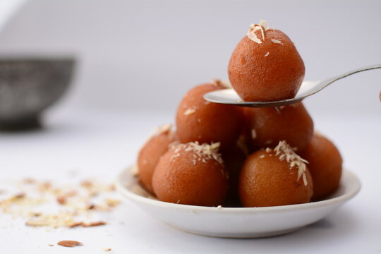 Gulab jamun with sweet syrup and almond on it