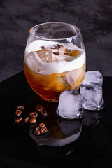 Cocktail White Russian con vodka, calua e panna fresca fotografato con cubetti di ghiaccio e chicchi di caffè 