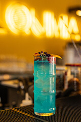 Cocktail chiamato Miami Ice con gin, vodka, rum bianco, blu curaçao, sweet and sour e Lemon soda servito in un cocktail bar serale