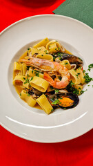 Pasta ai frutti di mare con cozze, vongole, gamberi e prezzemolo servita in un ristorante elegante 