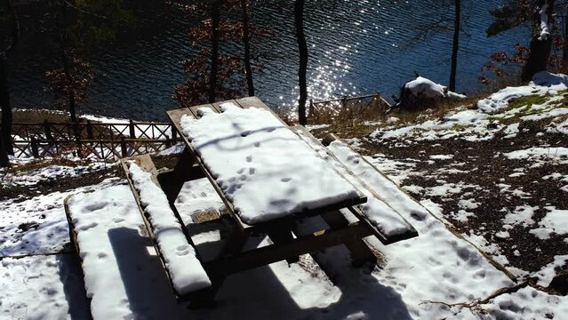 wooden table in snow by the lake