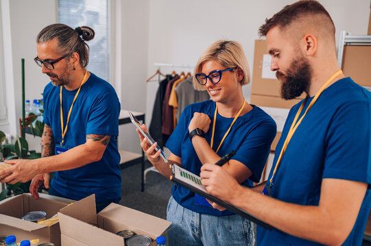 Volunteers working in a charity donation center and packing clothes and food