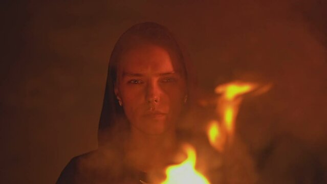 a girl in a black sweatshirt looks at a bowl of fire. High quality Full HD video recording. slow motion video