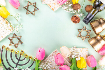 Passover, Pesah background. jewish Easter Passover spring holiday celebration, with accessories - menorah, matzo, spring flowers, wine bottle, gold wine glass, jewish david stars, copy space top view 