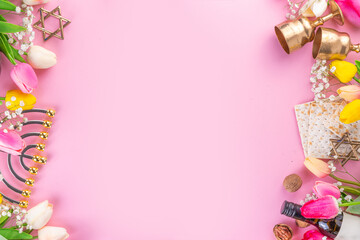 Passover, Pesah background. jewish Easter Passover spring holiday celebration, with accessories - menorah, matzo, spring flowers, wine bottle, gold wine glass, jewish david stars, copy space top view 