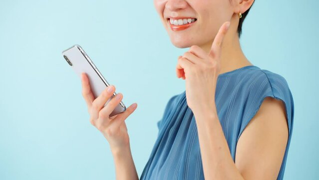 スマートフォンを使うワンピースを着た若い女性	