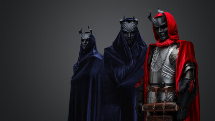 Portrait of dark cultists dressed in robes with hood and black horned masks.