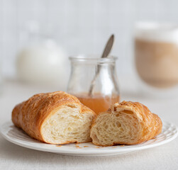 croissant with pear jam for the breakfast with a cup of coffee with milk. French breakfast