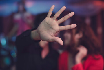 A man puts his hand out to cover the lens of the camera to prevent anyone from seeing him kissing his girlfriend. Strong parental guidance. Kissing scene. Off limits hand gesture.