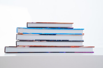 photobooks stacked on top of each other on a white table.