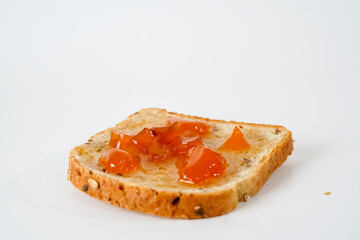 A slice of bread with apricot jam isolated on white background.