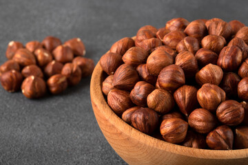 View of a bowl full of hazelnuts on a black background
