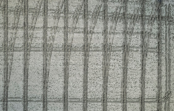 Overhead view of tire tracks in frost covered field