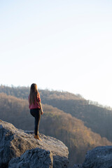 A young woman enjoys the view from the top of the mountain.