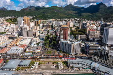 Port Louis, Mauritius - panoramic aerial view of the old and modern buildings at Waterfront in Port Louis, Capital of Mauritius with mountains in the background. Bird eyes view  - obrazy, fototapety, plakaty