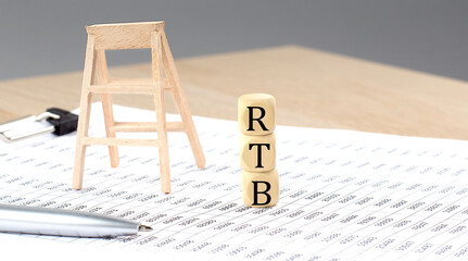 wooden cubes with the word RTB stand on a financial background, business concept.