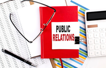 PUBLIC RELATIONS text on notebook with chart, calculator and pen