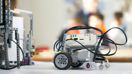 Elements of a robotic training model with wheels, cogwheels, wire and usb connector. Selective focus