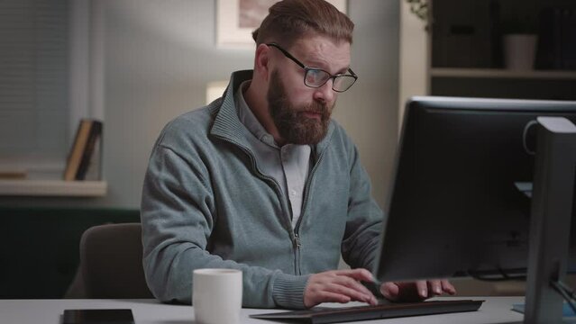 Mature bearded man suffering heartache while working on computer, heart desease concept