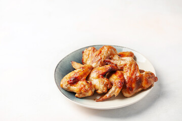 Chicken wings grill  in a plate on a bright background.