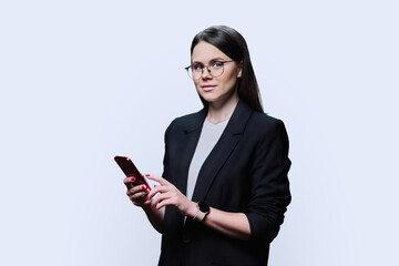 Young business woman using smartphone on white studio background
