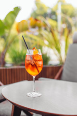 A glass of orange cocktail Spritz on a table in a bar