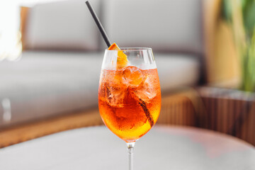 A glass of orange cocktail Spritz on a table in a bar