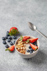 Oatmeal granola with yogurt, berries and nuts in a bowl on the table. Healthy breakfast