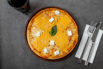 Italian pizza with four cheeses and lots of mozzarella on a cutting board