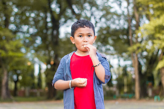 Boys Snacking Food In Park