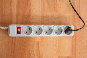 Extension cord power cable with a plug, power strip with sockets with power indicator