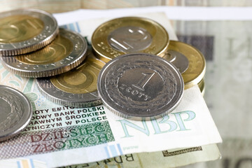 Several Polish zloty coins are on the banknote