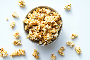 Caramel popcorn in a bowl, on a white background