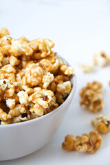 Caramel popcorn in a bowl, on a white background