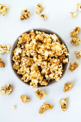 Caramel popcorn in a bowl, on a white background