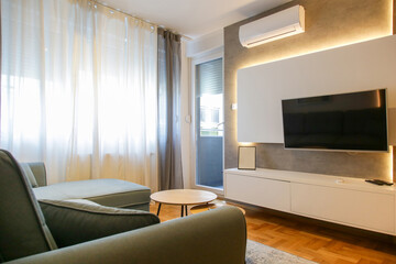 Living room with big tv hanging on a decorative wall 
