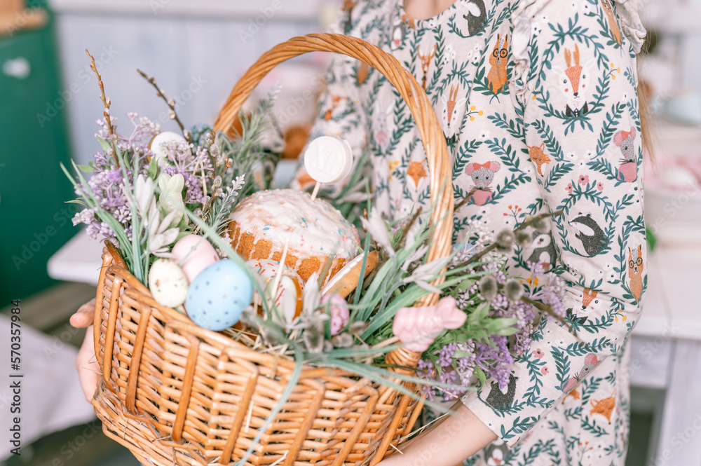 Wall mural Russia, Moscow, 04.09.2022. happy easter holiday time in spring season. little eight year old kid girl holds basket with painted eggs and easter baked cakes. festive home decor. traditional food