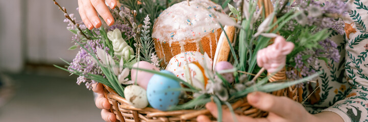 Russia, Moscow, 04.09.2022. happy easter holiday time in spring season. family and little kids sisters holds basket with painted eggs easter baked cakes. festive home decor. traditional food. banner