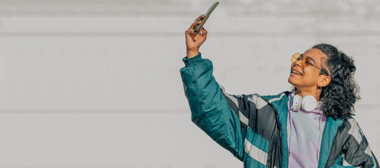 girl with mobile phone or smartphone outdoors recording or making selfie photo
